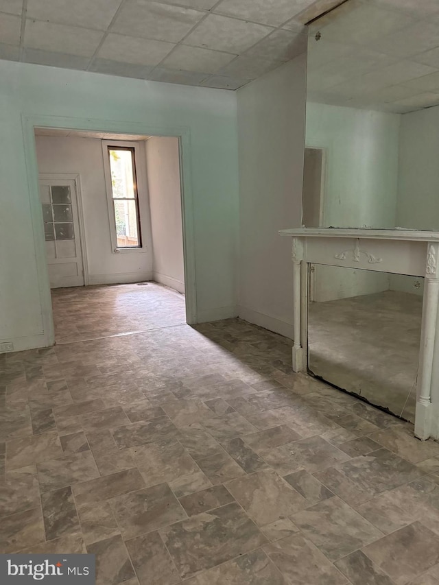 unfurnished living room featuring a drop ceiling