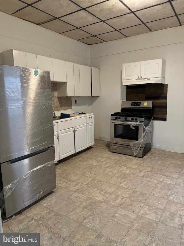 kitchen with ventilation hood, appliances with stainless steel finishes, and white cabinetry