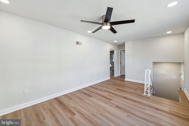 unfurnished room featuring light hardwood / wood-style floors, a textured ceiling, and ceiling fan