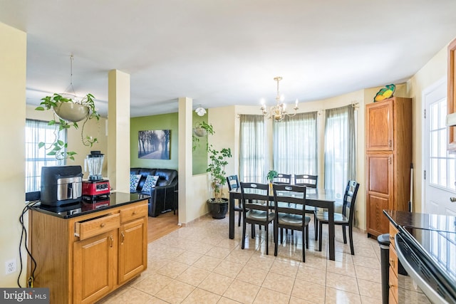 dining room featuring baseboards, a healthy amount of sunlight, a chandelier, and light tile patterned flooring