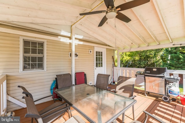 wooden deck with outdoor dining area, a ceiling fan, and area for grilling