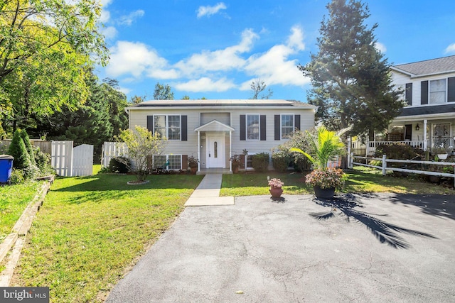 raised ranch with fence and a front yard