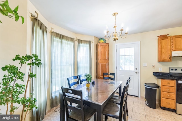 tiled dining room featuring a chandelier