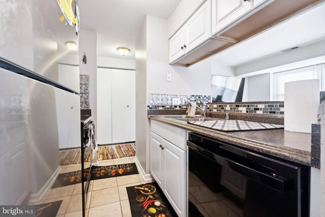 kitchen with dark countertops, dishwasher, and white cabinets