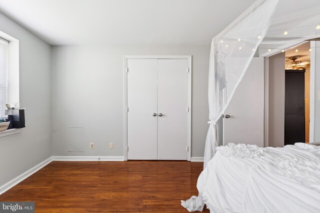 bedroom featuring a closet, baseboards, and wood finished floors