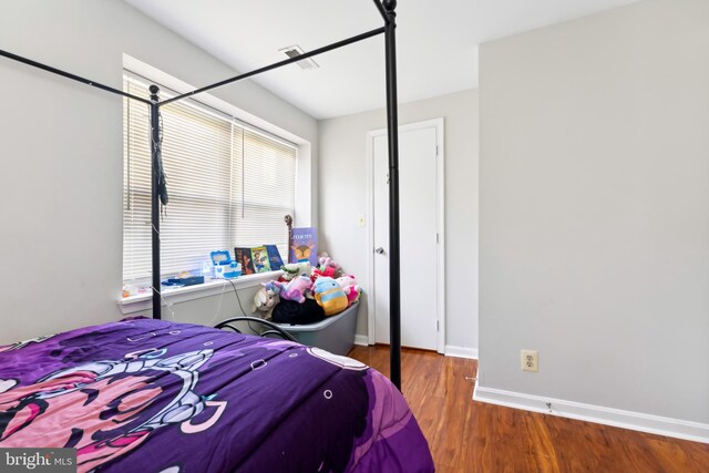 bedroom with baseboards and wood finished floors