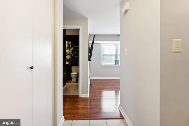 hallway with wood finished floors and baseboards