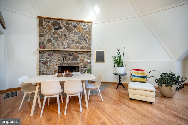 621 Paradise Hts, Oakland, MD 21550 - dining space featuring visible vents, baseboards, vaulted ceiling, wood finished floors, and a stone fireplace