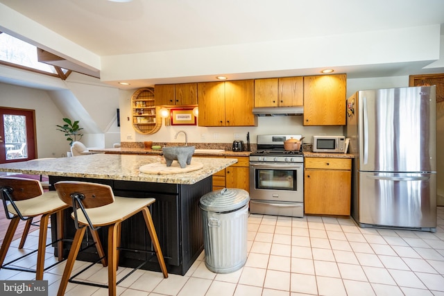 621 Paradise Hts, Oakland, MD 21550 - kitchen featuring a kitchen breakfast bar, brown cabinets, stainless steel appliances, a kitchen island, and under cabinet range hood