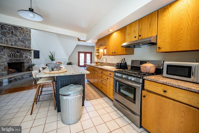 621 Paradise Hts, Oakland, MD 21550 - kitchen featuring white microwave, under cabinet range hood, brown cabinets, a sink, and stainless steel range with gas cooktop