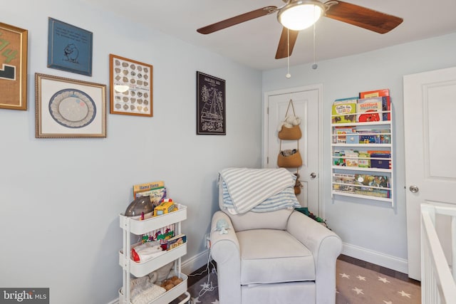 sitting room with ceiling fan and dark hardwood / wood-style floors