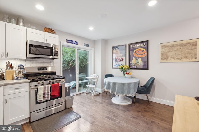 kitchen featuring tasteful backsplash, white cabinets, dark hardwood / wood-style floors, and stainless steel appliances