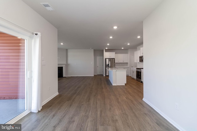 kitchen with hardwood / wood-style floors, a center island, white cabinets, sink, and appliances with stainless steel finishes