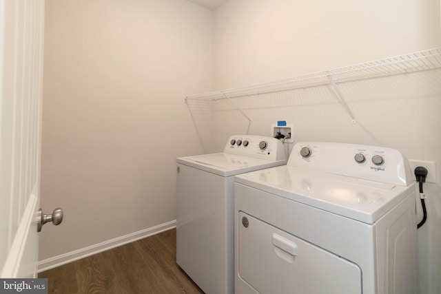 laundry room featuring washing machine and clothes dryer and dark hardwood / wood-style floors