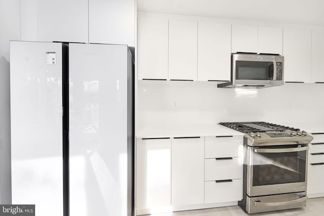 kitchen featuring stainless steel appliances and white cabinets