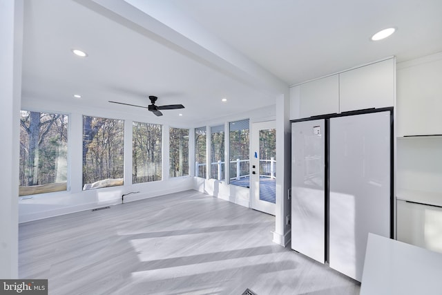 unfurnished sunroom featuring ceiling fan