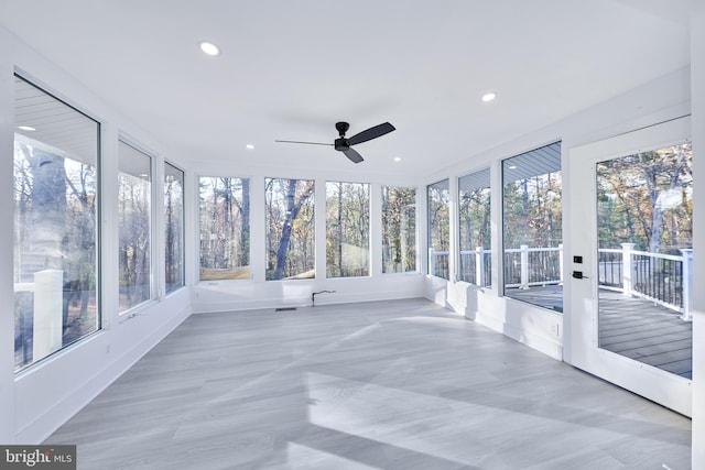 unfurnished sunroom featuring ceiling fan