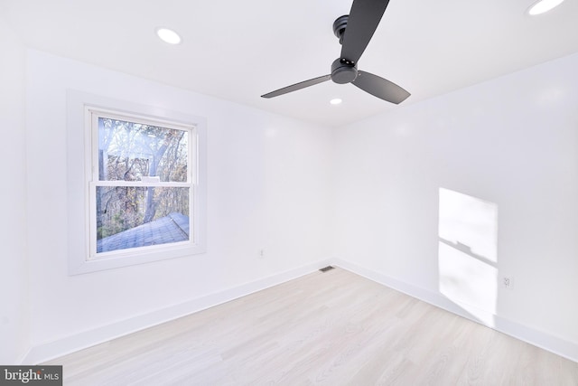 empty room with ceiling fan and light hardwood / wood-style flooring