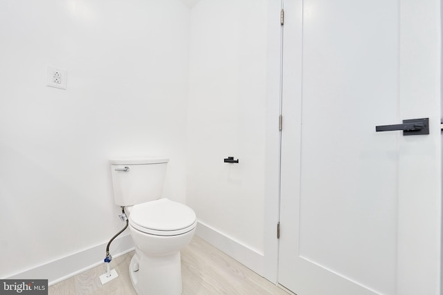 bathroom with toilet and hardwood / wood-style flooring