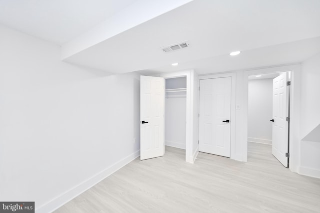 unfurnished bedroom with light wood-type flooring and a closet