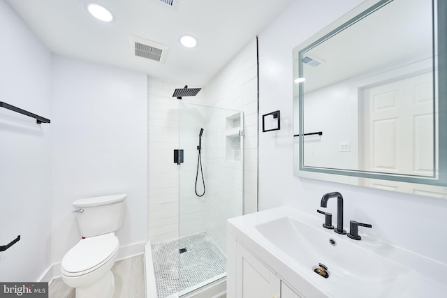 bathroom featuring toilet, hardwood / wood-style floors, a shower with door, and vanity