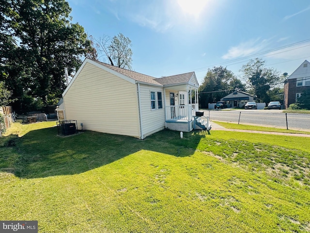 view of side of property featuring cooling unit and a lawn