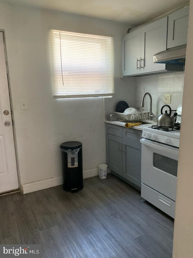 kitchen with dark hardwood / wood-style floors, gray cabinets, sink, and white range with gas cooktop