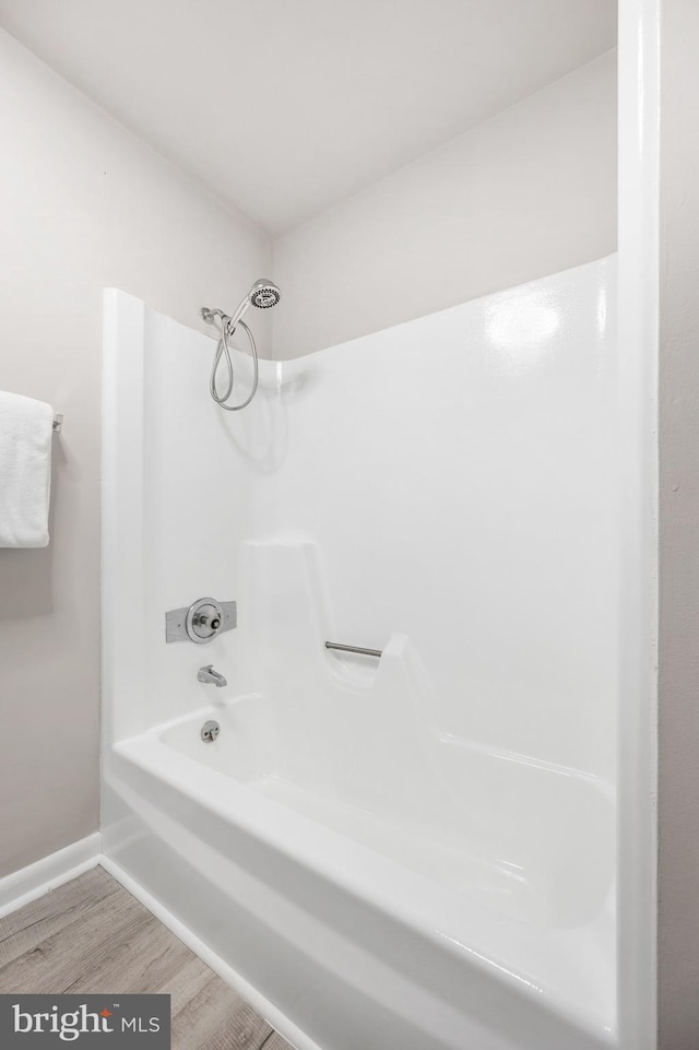 bathroom with hardwood / wood-style floors and  shower combination