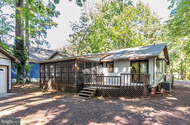 back of house with cooling unit, a sunroom, and a wooden deck