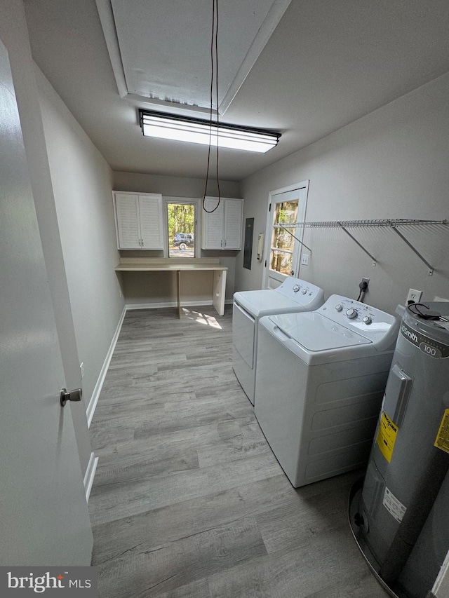 clothes washing area with independent washer and dryer, light hardwood / wood-style floors, water heater, and a wealth of natural light