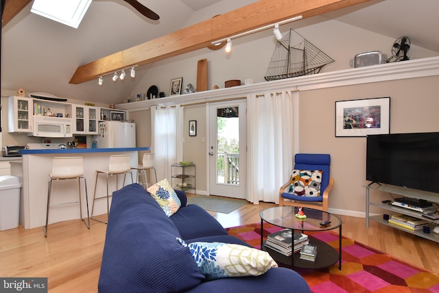 living room featuring track lighting, lofted ceiling with beams, ceiling fan, and light wood-type flooring