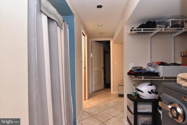 hallway featuring light tile patterned flooring and separate washer and dryer