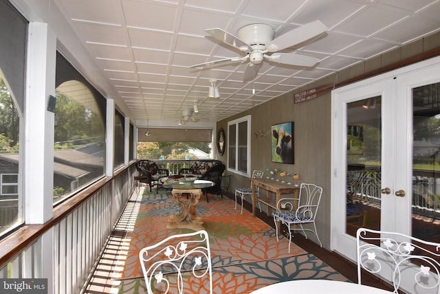 sunroom featuring ceiling fan and french doors