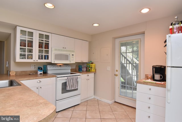 kitchen with light tile patterned flooring, white appliances, white cabinets, and sink