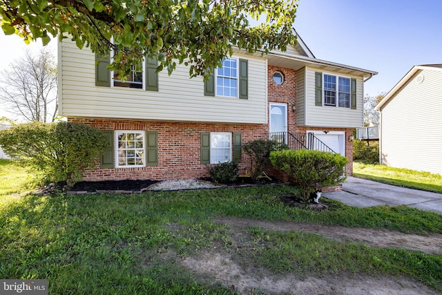 bi-level home with a garage and a front lawn