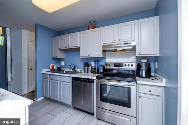 kitchen with sink, stainless steel appliances, and light hardwood / wood-style flooring