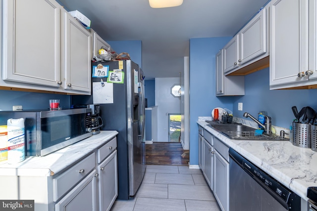 kitchen featuring appliances with stainless steel finishes, sink, and light hardwood / wood-style flooring