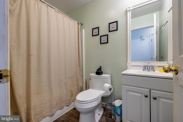 bathroom with a shower with curtain, vanity, hardwood / wood-style floors, and toilet