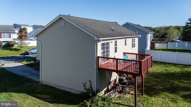 rear view of property featuring a yard and a deck