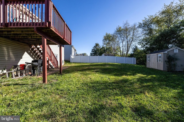 view of yard with a wooden deck and a storage unit