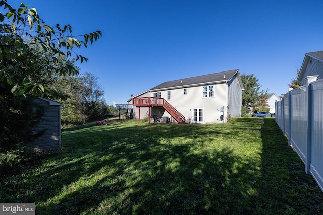 back of house with a lawn and a deck