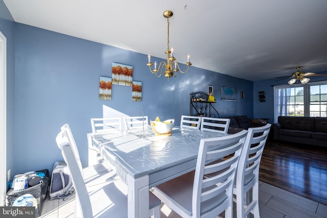 dining room featuring ceiling fan with notable chandelier and dark hardwood / wood-style floors