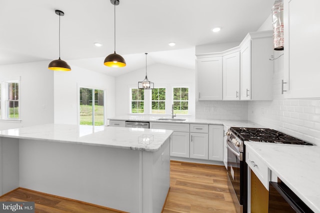 kitchen featuring decorative light fixtures, appliances with stainless steel finishes, light hardwood / wood-style floors, and white cabinetry