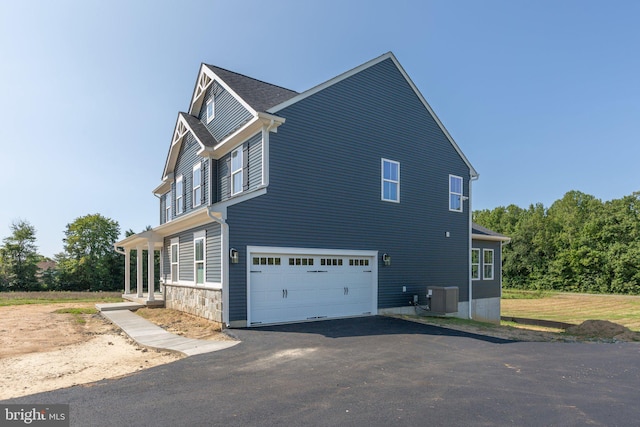 view of side of home with central AC and a garage