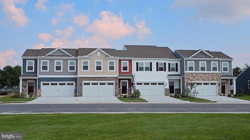 view of property featuring a garage and a yard