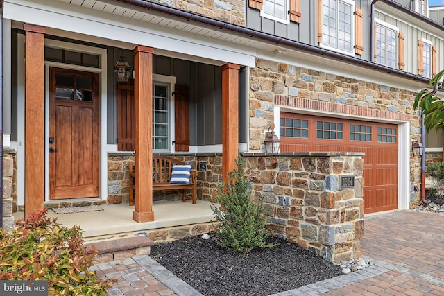 entrance to property featuring a garage and covered porch