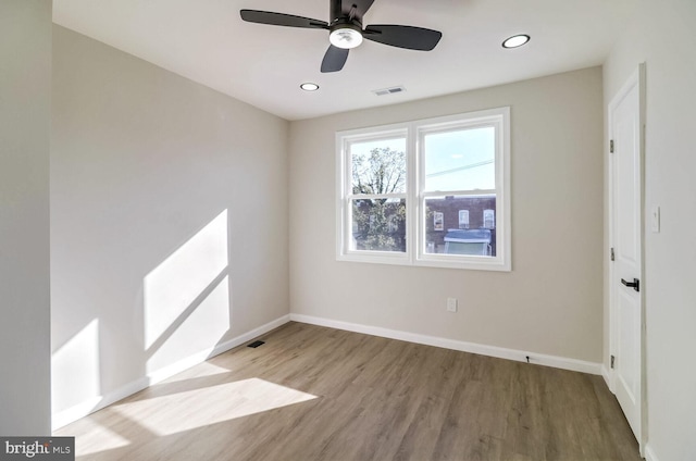 empty room featuring visible vents, baseboards, and wood finished floors