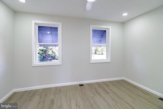 empty room with light wood-style floors, baseboards, and a healthy amount of sunlight