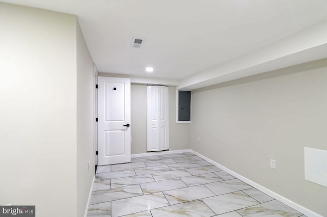 finished basement featuring baseboards, recessed lighting, marble finish floor, and electric panel