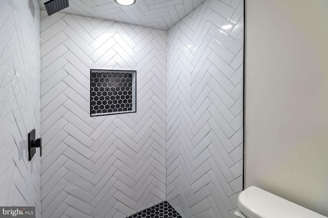 bathroom featuring toilet and tiled shower
